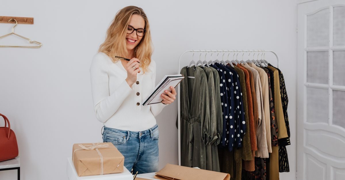 A shop owner taking inventory in a clothing boutique
